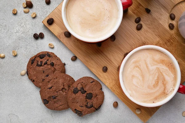 Cups with tasty aromatic coffee and cookies on grey table — Stock Photo, Image