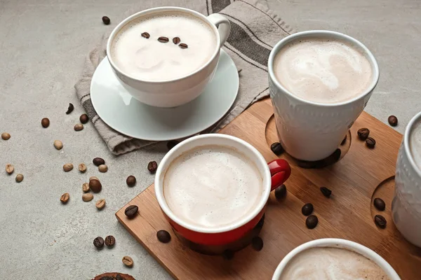 Veel kopjes met smakelijke aromatische koffie op grijze tafel — Stockfoto