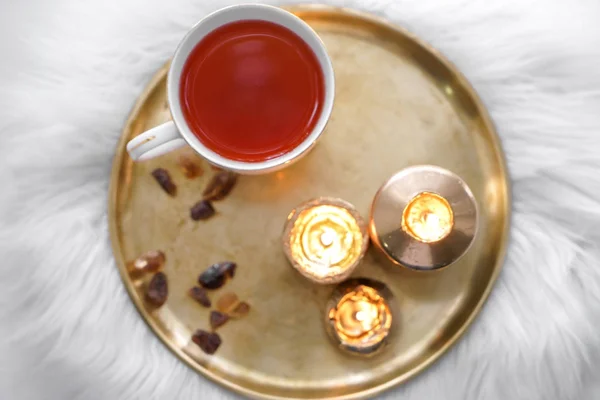 Beautiful burning candles with cup of aromatic tea on metal tray — Stock Photo, Image
