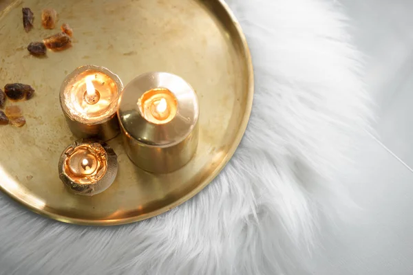 Красивые золотые горящие свечи на металлическом подносе — стоковое фото