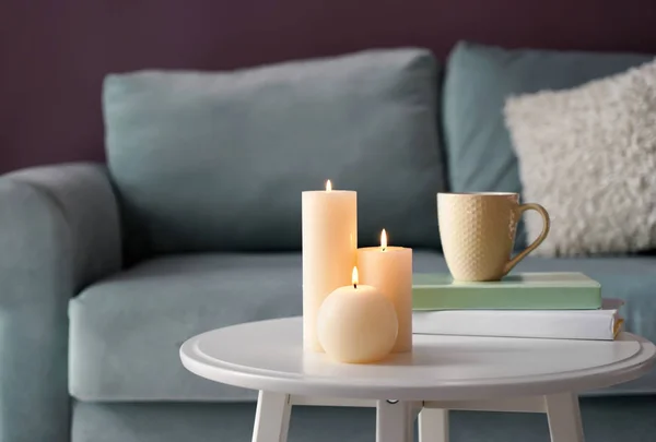 Красиві палаючі свічки з книгами на білому столі в приміщенні — стокове фото