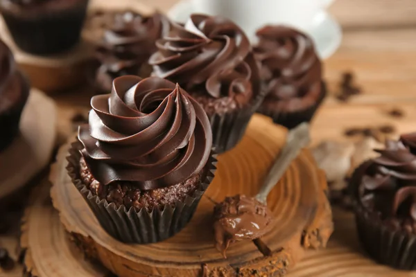 Deliciosos cupcakes de chocolate na placa de madeira — Fotografia de Stock