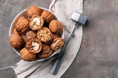 Lezzetli ceviz ile kase ve gri masaya çekiç