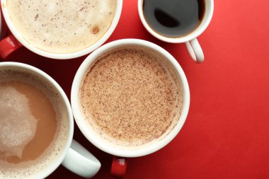 Düz renkli arka plan üzerinde lezzetli aromatik Kahve kupaları yatıyordu