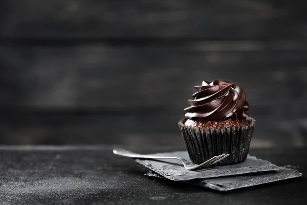 Delicious chocolate cupcake on dark table — Stock Photo, Image