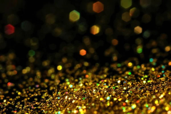 Koyu arka plan üzerinde parlak altın glitter — Stok fotoğraf