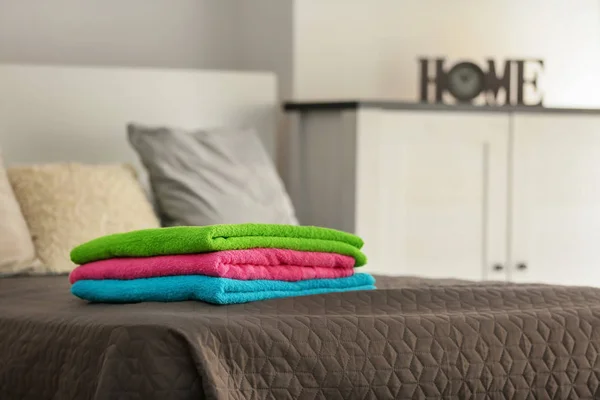 Стопка чистых махровых полотенец на кровати — стоковое фото