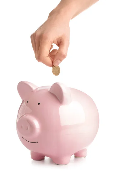 Woman putting coin into piggy bank on white background — Stock Photo, Image