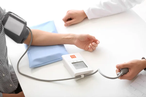 Médico do sexo masculino medindo a pressão arterial de paciente do sexo feminino no hospital — Fotografia de Stock