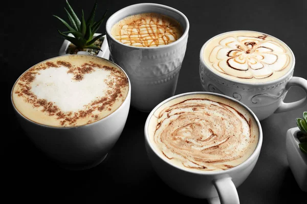 Copos com café aromático saboroso no fundo preto — Fotografia de Stock