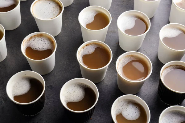 Багато пластикових чашок зі смачною ароматичною кавою на столі — стокове фото