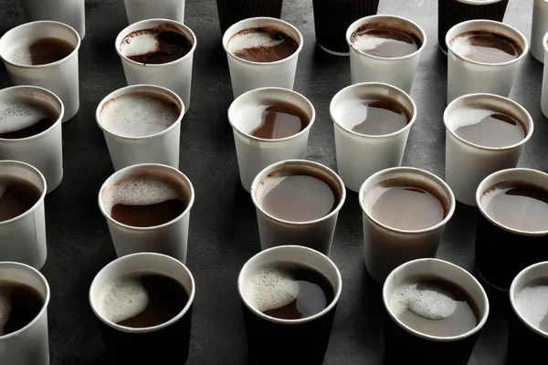 Багато пластикових чашок зі смачною ароматичною кавою на столі — стокове фото