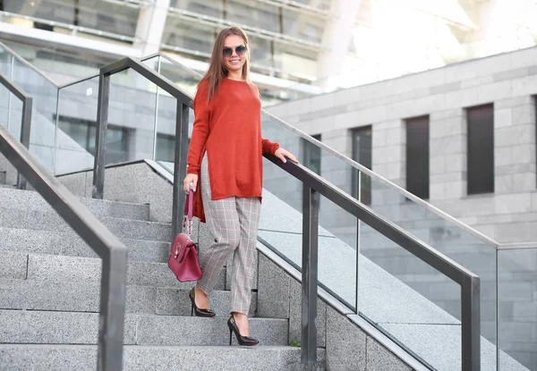 Fashionable young woman on stairs outdoors — Stock Photo, Image