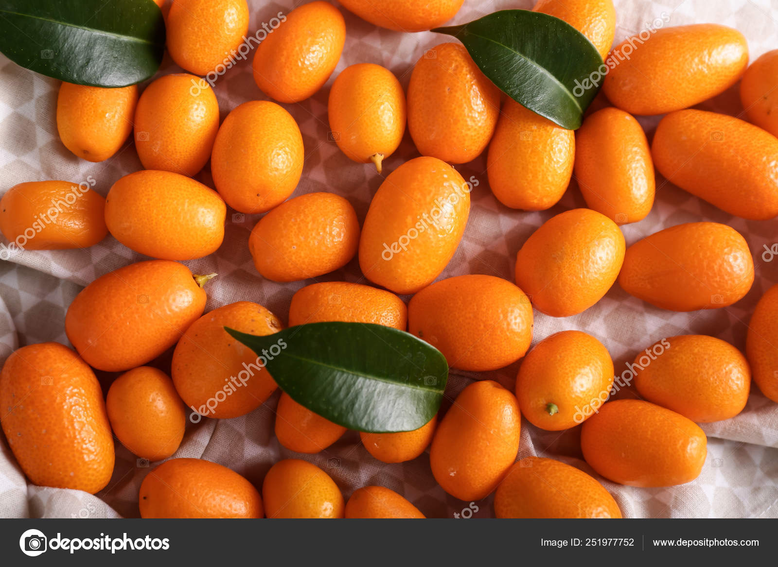 Delicious kumquat fruit on table Stock Photo by ©serezniy 251977752