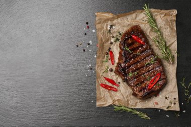 Parşömen lezzetli pişmiş et ve baharat koyu arka plan üzerinde