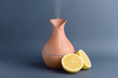 Aroma Yağı difüzör ve gri arka plan üzerinde narenciye meyve
