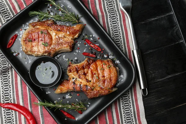 Assiette avec viande cuite savoureuse, huile et épices sur la table — Photo