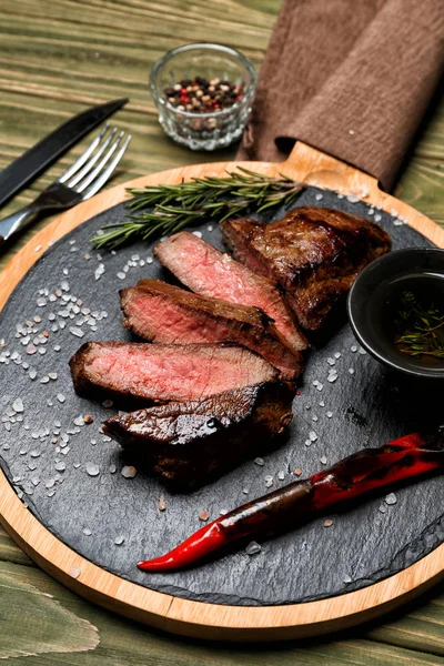 Plateau avec viande cuite savoureuse sur table en bois — Photo