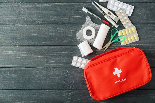 First aid kit on wooden background — Stock Photo, Image