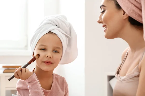 Niedliche kleine Tochter und ihre Mutter beim Schminken zu Hause — Stockfoto