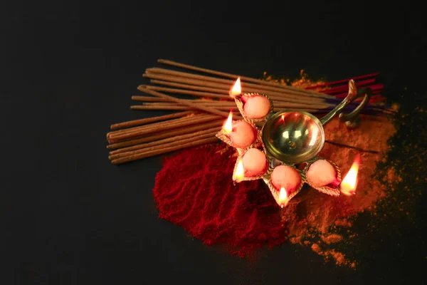 Diya lamp with spices for celebration of Divaly on dark background — Stock Photo, Image