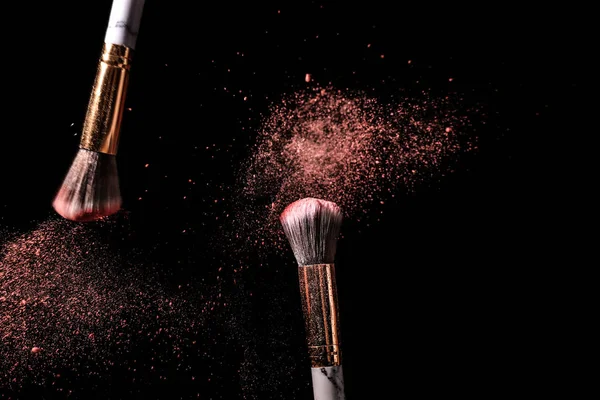 Make-up penselen en uitbarsting van eyeshadows op donkere achtergrond — Stockfoto
