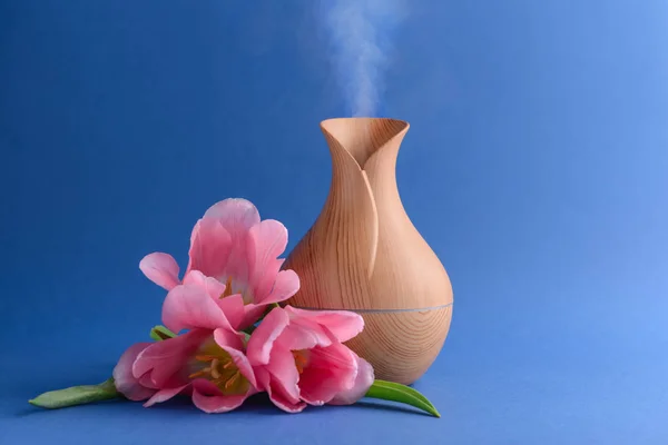 Aroma olie diffusor en bloemen op kleur achtergrond — Stockfoto