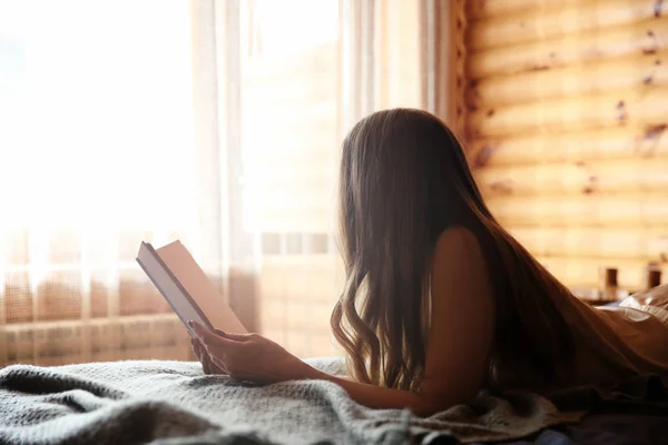 Hermosa mujer leyendo libro en la mañana en el resort de invierno — Foto de Stock