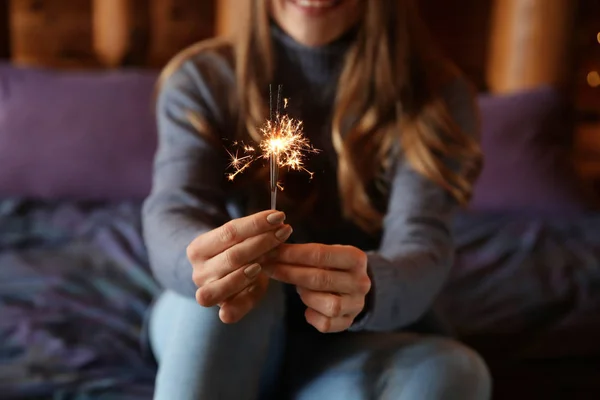 Young woman with sparklers at home — Stock Photo, Image