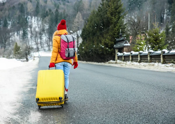 Woman with suitcase at winter resort — Stock Photo, Image