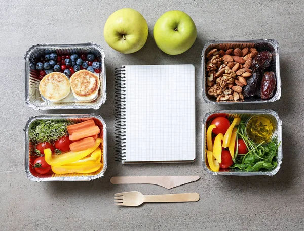 Containers with delicious food and blank notebook on grey background — Stock Photo, Image