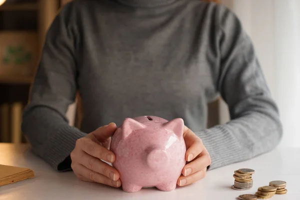 Woman with piggy bank at table. Concept of savings — Stock Photo, Image