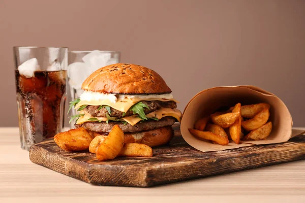 Tasty burger and fried potato on table — Stock Photo, Image