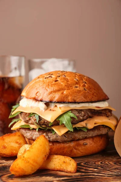 Tasty burger and fried potato on table — Stock Photo, Image