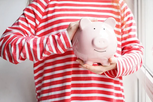 Woman with piggy bank near window. Concept of savings — Stock Photo, Image