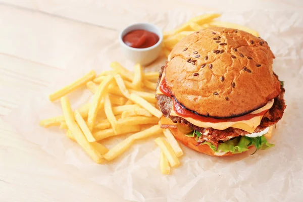 Tasty burger and french fries on table — Stock Photo, Image