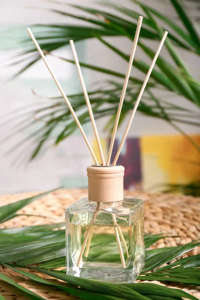 Reed diffuser and tropical leaves in room — Stock Photo, Image