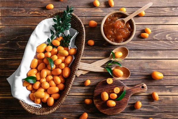 Composition with delicious kumquat fruit and jam on table