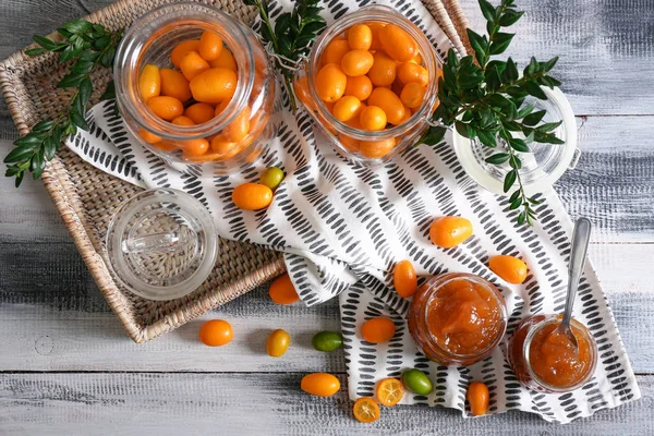Composition with delicious kumquat fruit and jam on table — Stock Photo, Image
