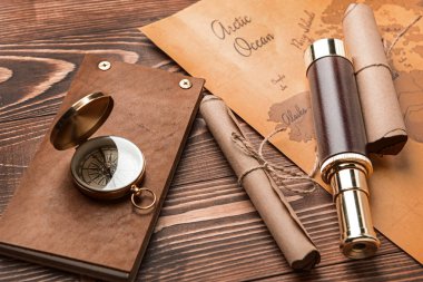 Defter, spyglass, verilirse, pusula ve dünya harita üzerinde ahşap arka plan. Seyahat kavramı