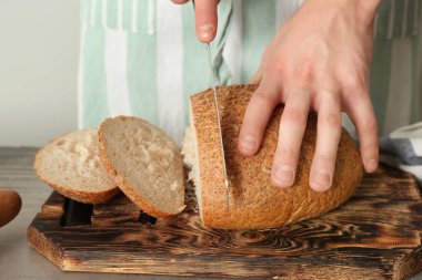 Adam mutfakta, closeup taze pişmiş ekmek kesme