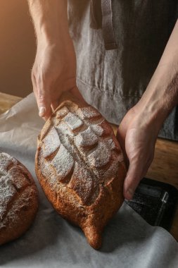 Adam masada, closeup taze pişmiş ekmek ile