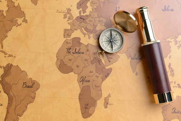 Spyglass e bússola no mapa do mundo. Conceito de viagem — Fotografia de Stock