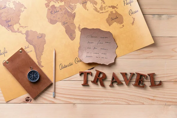 Cuaderno, hoja de papel vieja, brújula y mapa del mundo sobre fondo de madera. Concepto de viaje — Foto de Stock