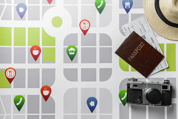 Fotocamera, passaporto e biglietti sulla mappa della città. Concetto di viaggio — Foto Stock