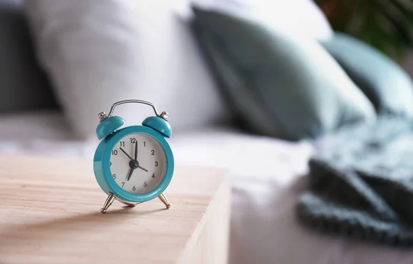 Alarm clock on table in bedroom — Stock Photo, Image