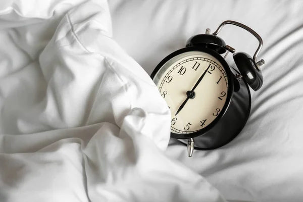 Reloj despertador en la cama por la mañana —  Fotos de Stock