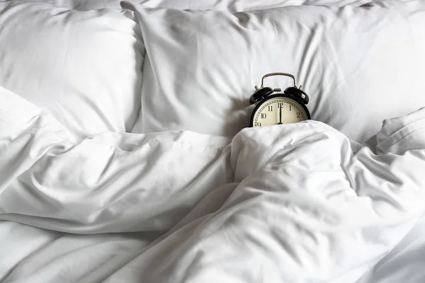 Alarm clock on bed in morning — Stock Photo, Image