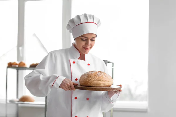 Θηλυκό σεφ με φρεσκοψημένο ψωμί στην κουζίνα — Φωτογραφία Αρχείου