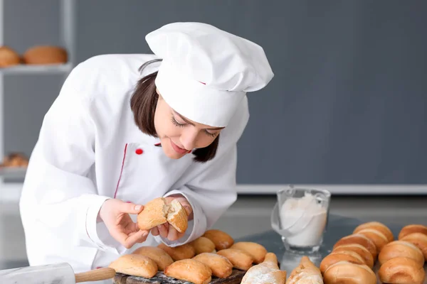 Vrouwelijke chef-kok met vers gebakken gebakjes in de keuken — Stockfoto